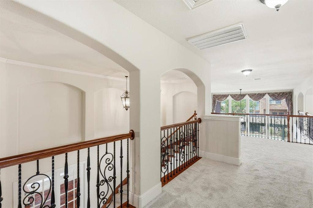 509 Wentworth Lane, Murphy, TX 75094 Arched architectural details, wrought iron and wood stair railing, recessed wall niches, and light-colored carpeting
