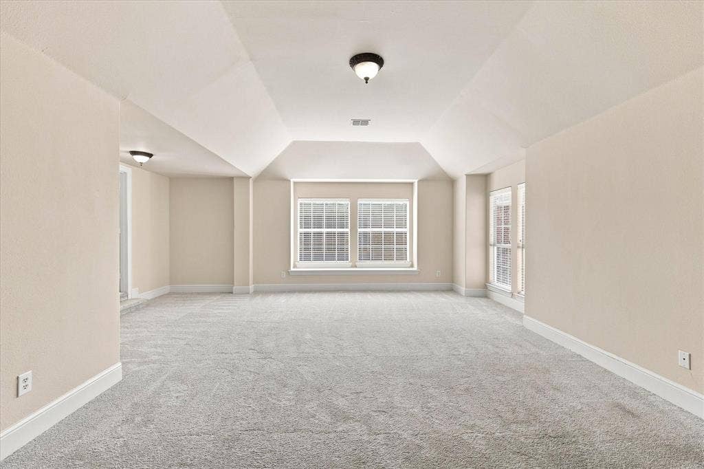 509 Wentworth Lane, Murphy, TX 75094 Expansive room featuring light-toned carpet, multiple windows, and a vaulted ceiling detail