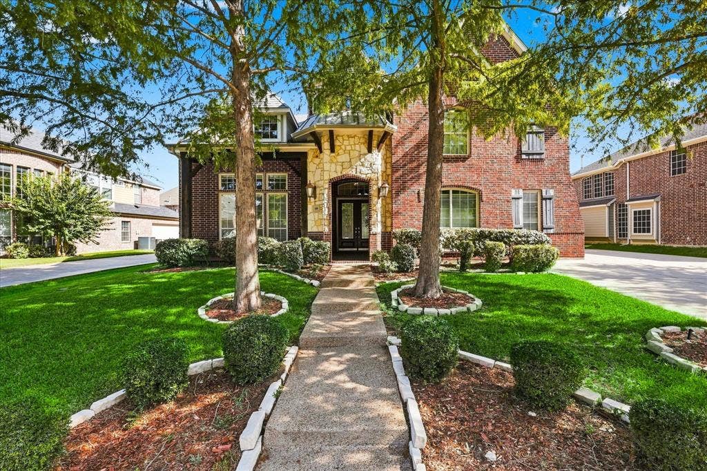 509 Wentworth Lane, Murphy, TX 75094 Brick and stone facade, arched entryway, gabled roofline, mature trees, concrete pathway