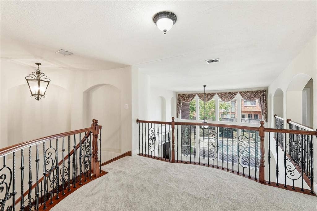 509 Wentworth Lane, Murphy, TX 75094 Upper-level landing with wrought iron and wood-finish railings, recessed archways, and a decorative pendant light fixture