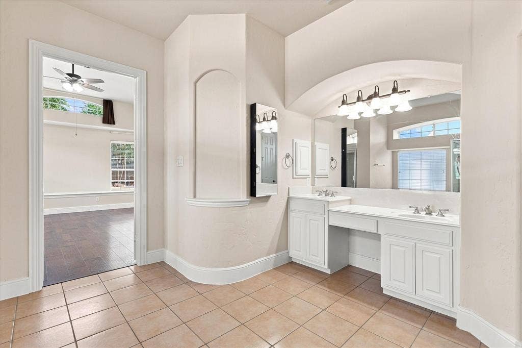 509 Wentworth Lane, Murphy, TX 75094 Dual vanity with integrated sinks, white cabinetry, and a large wall-mounted mirror