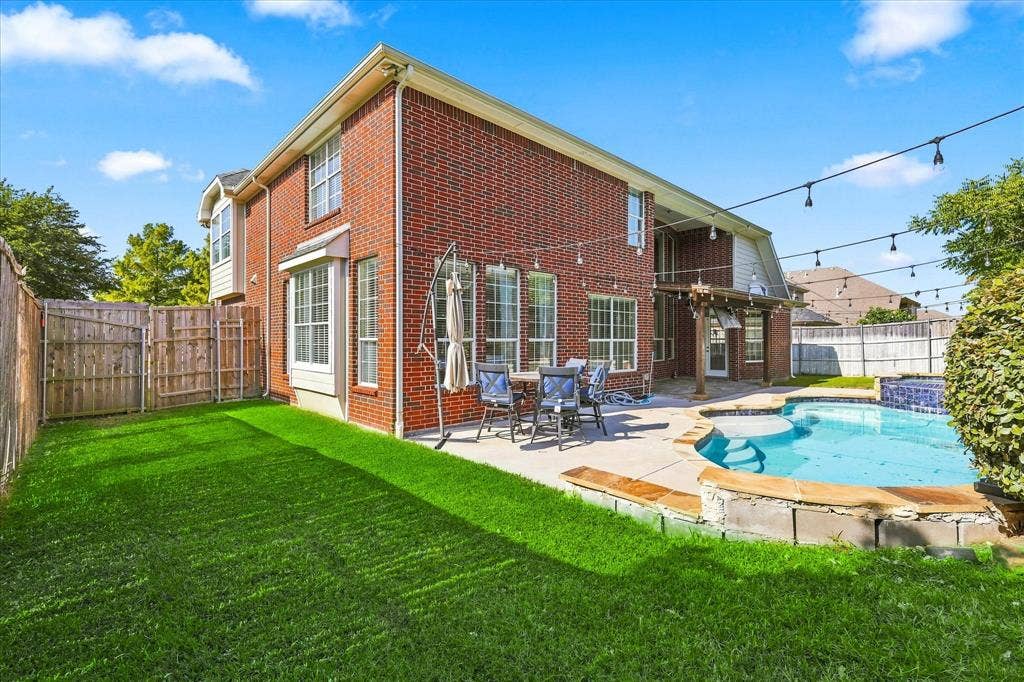 509 Wentworth Lane, Murphy, TX 75094 Brick exterior with bay windows, a private pool, and a paved patio area