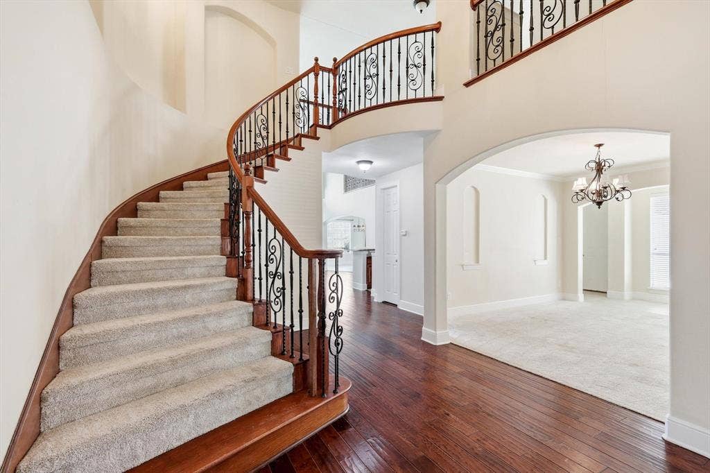509 Wentworth Lane, Murphy, TX 75094 Grand curved staircase with decorative wrought iron balusters and rich wood handrails