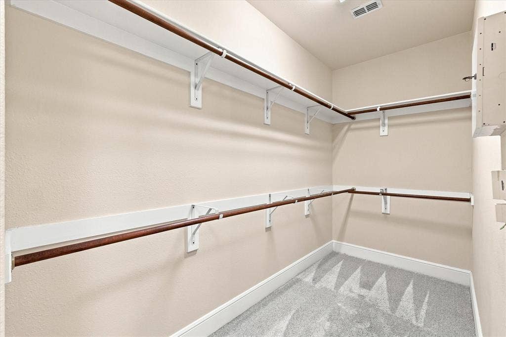 509 Wentworth Lane, Murphy, TX 75094 Walk-in closet with light-colored walls, white shelving, and wood-finish rods