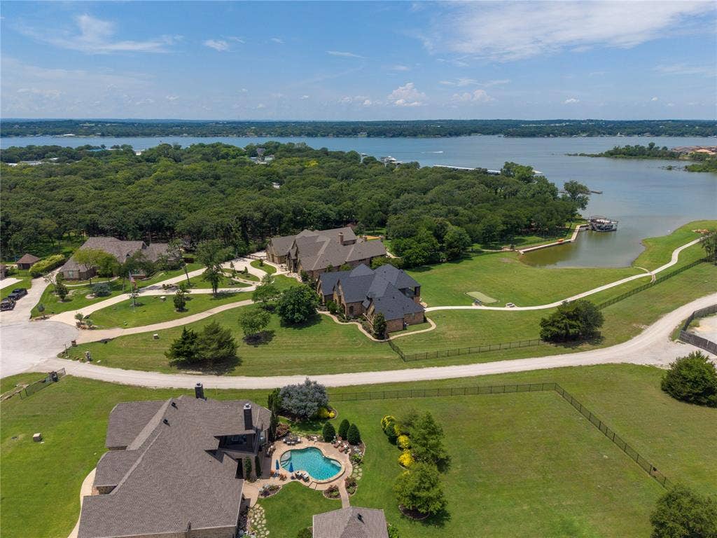 6412 Preferred Drive, Fort Worth, TX 76179 Expansive estate featuring a large inground pool with stone surround, manicured lawns, mature trees, a private boat dock, and direct lake access