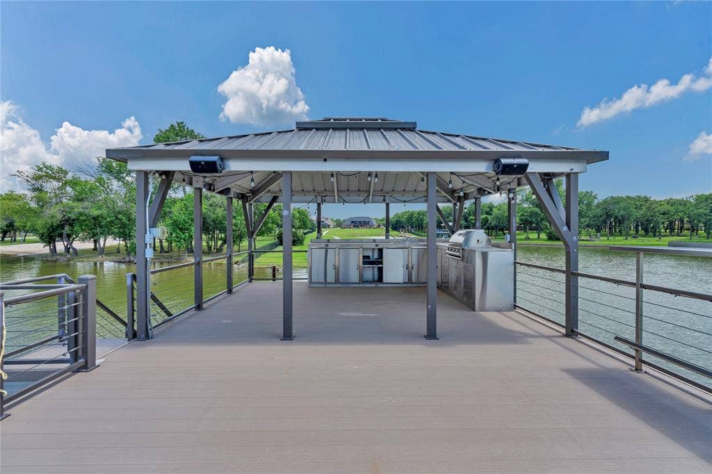 6412 Preferred Drive, Fort Worth, TX 76179 Waterfront gazebo with composite decking, featuring a built-in stainless steel outdoor kitchen, integrated lighting, and cable railings