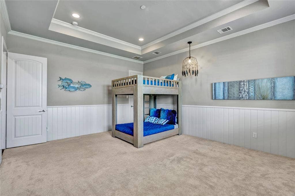 6412 Preferred Drive, Fort Worth, TX 76179 Recessed lighting illuminating a tray ceiling, white paneled wainscoting, and carpeted flooring