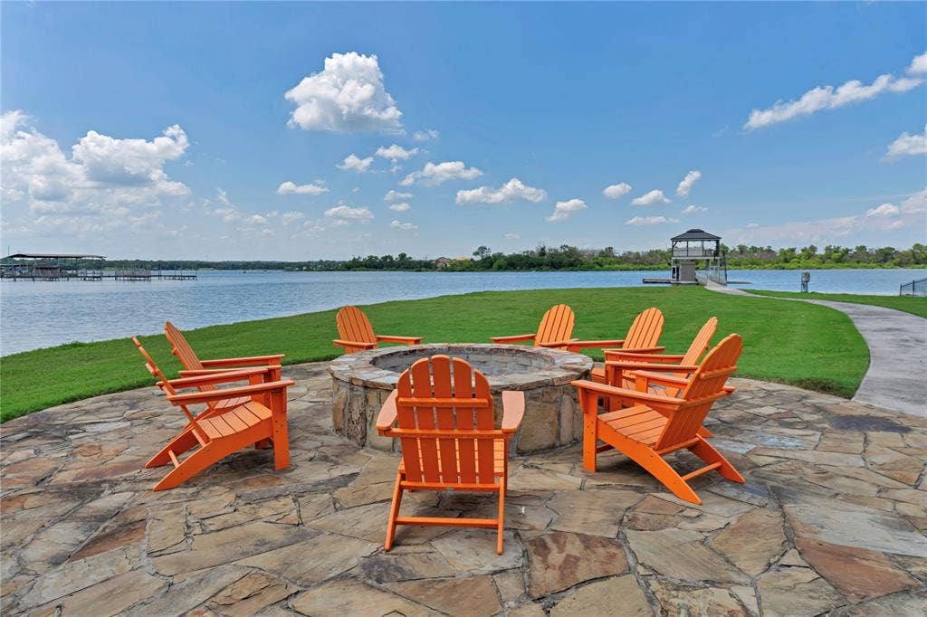6412 Preferred Drive, Fort Worth, TX 76179 Flagstone patio with a built-in stone fire pit, surrounded by Adirondack chairs