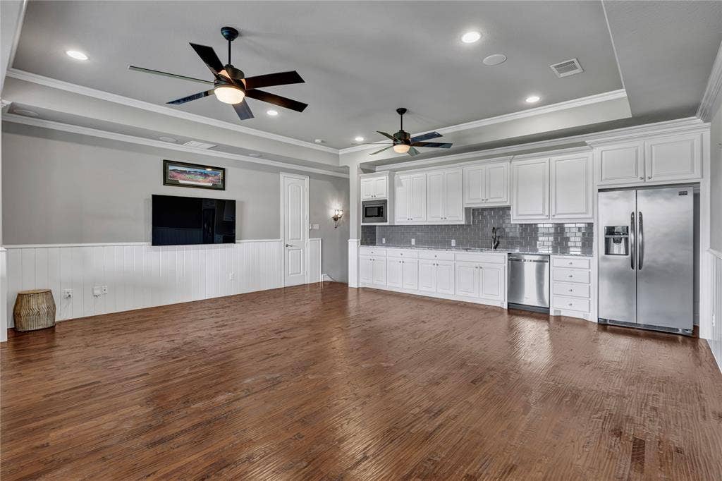 6412 Preferred Drive, Fort Worth, TX 76179 Expasnsive game room with built-in cabinets, refridgerator, sink, dishwasher and microwave. Perfect to host gamenight.