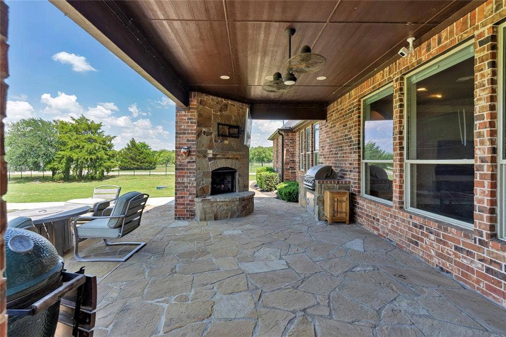 6412 Preferred Drive, Fort Worth, TX 76179 Expansive covered patio featuring flagstone flooring and a stone fireplace
