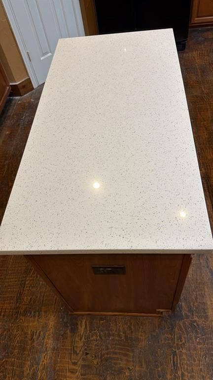 4506 Burnhill Drive, Plano, TX 75024 Kitchen island with a light-toned, speckled countertop and integrated power outlets, set against wood-finish flooring
