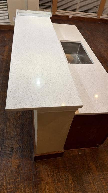4506 Burnhill Drive, Plano, TX 75024 Kitchen island with white speckled countertop, integrated stainless steel sink, and wood-finish flooring