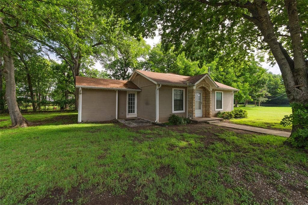 313 N Roe Street, White Settlement, TX 76108 Single-story residence featuring a covered entry, stone facade accents, and tan siding