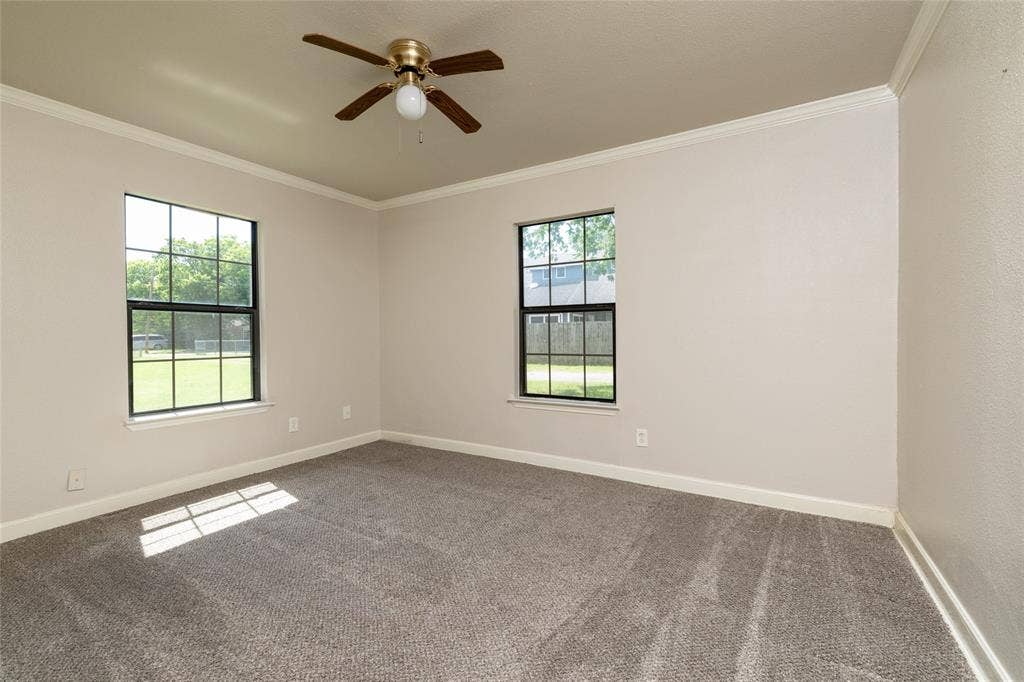 313 N Roe Street, White Settlement, TX 76108 Spacious room featuring neutral carpeting, light-toned walls, and white crown molding