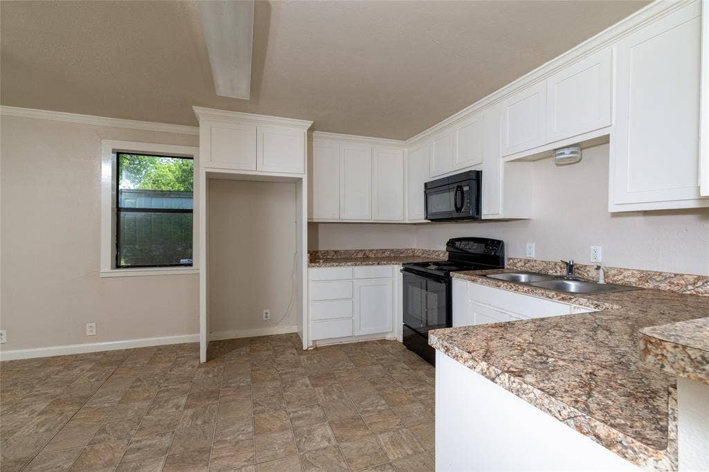 313 N Roe Street, White Settlement, TX 76108 Kitchen featuring white cabinetry, stone-look countertops, and an undermount double-basin sink