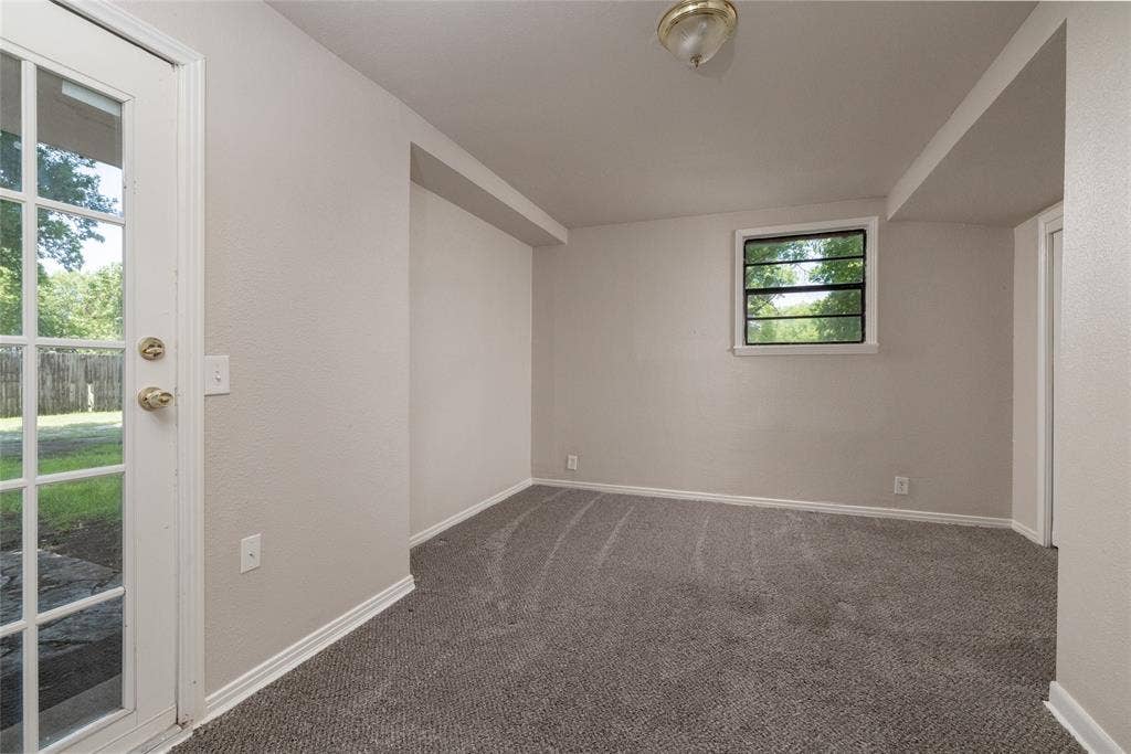 313 N Roe Street, White Settlement, TX 76108 Carpeted interior space featuring a glass-paneled exterior door, a rear-facing window, recessed lighting, and neutral wall finishes