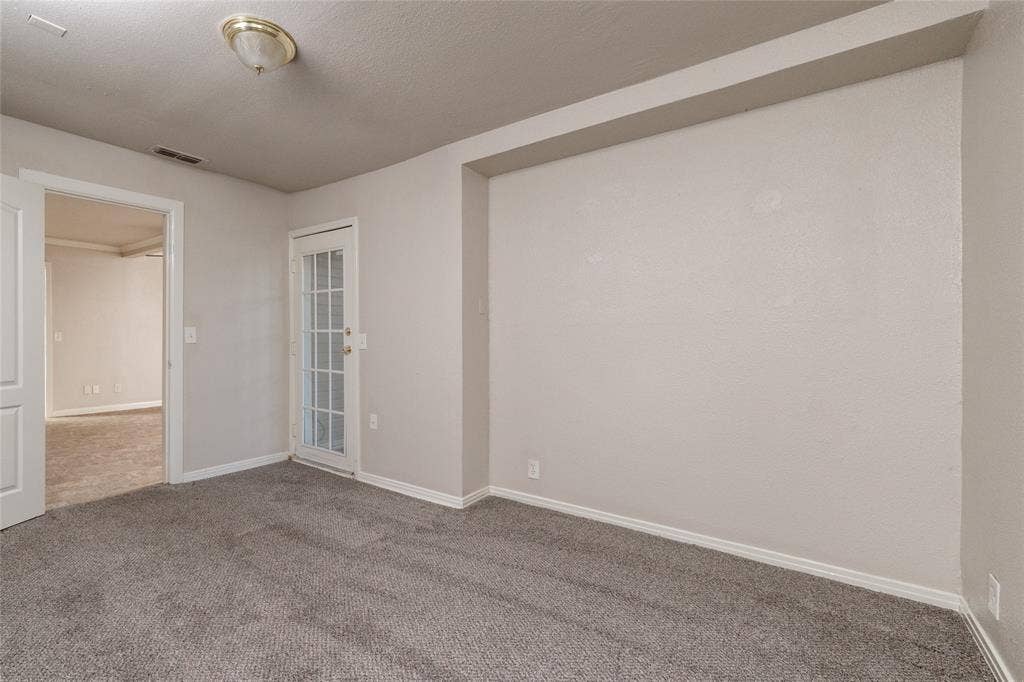 313 N Roe Street, White Settlement, TX 76108 Carpeted room featuring a glass-paneled door, recessed ceiling, and a flush mount light fixture