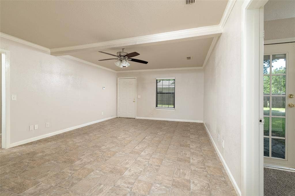 313 N Roe Street, White Settlement, TX 76108 Spacious room with durable tile flooring, crown molding, and a ceiling fan