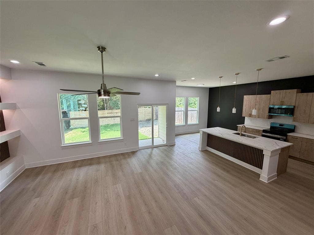 2823 Curvilinear Court, Dallas, TX 75227 Open-concept living space featuring wood-finish flooring, recessed lighting, and a contemporary ceiling fan