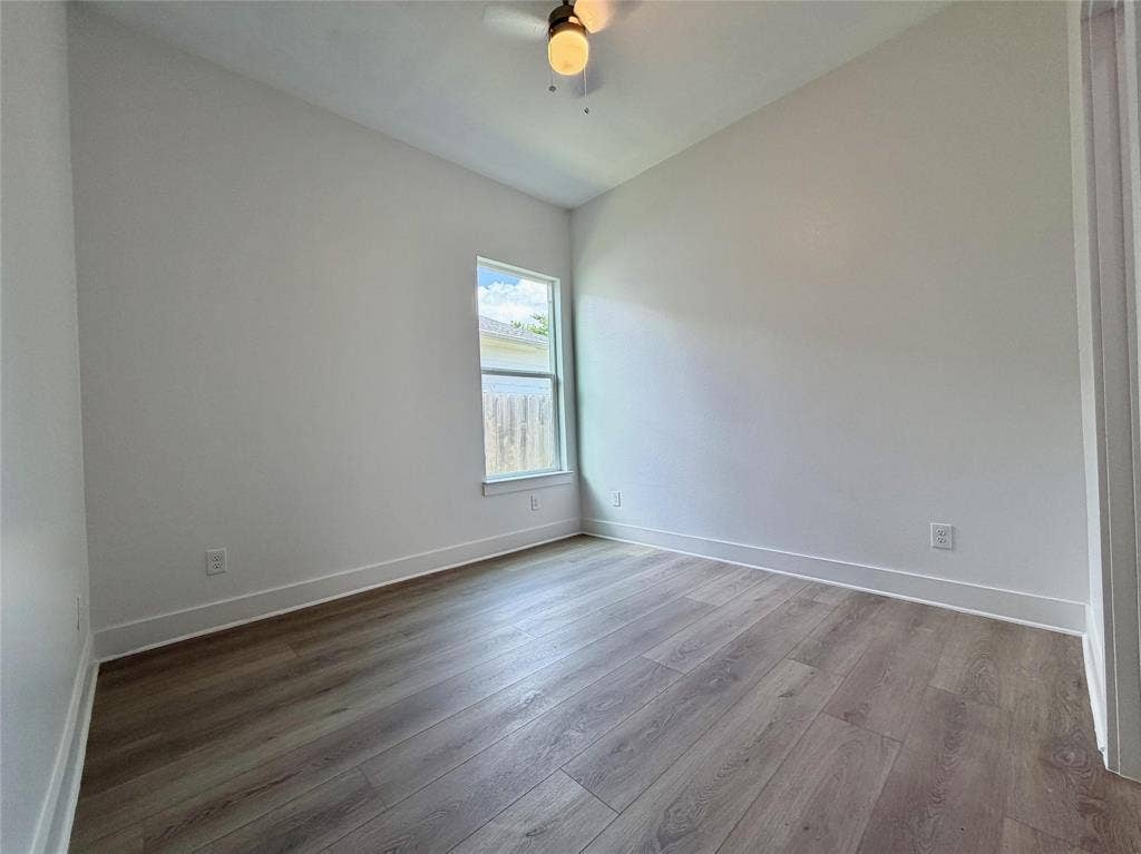 2823 Curvilinear Court, Dallas, TX 75227 Bedroom 2 featuring wood-finish flooring, a ceiling fan with integrated lighting, and a single window offering exterior views