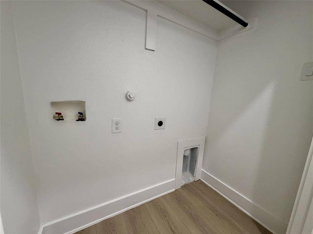 2823 Curvilinear Court, Dallas, TX 75227 Dedicated laundry alcove featuring light wood-finish flooring, white walls, and a hanging rod