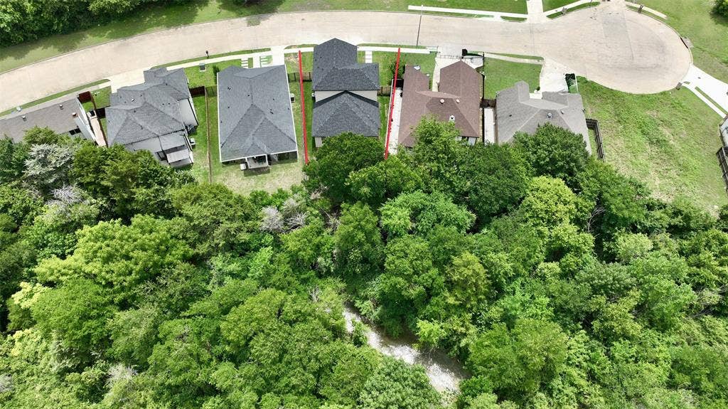 2823 Curvilinear Court, Dallas, TX 75227 Aerial perspective showcasing a residential property with a dark shingle roof and surrounding green spaces