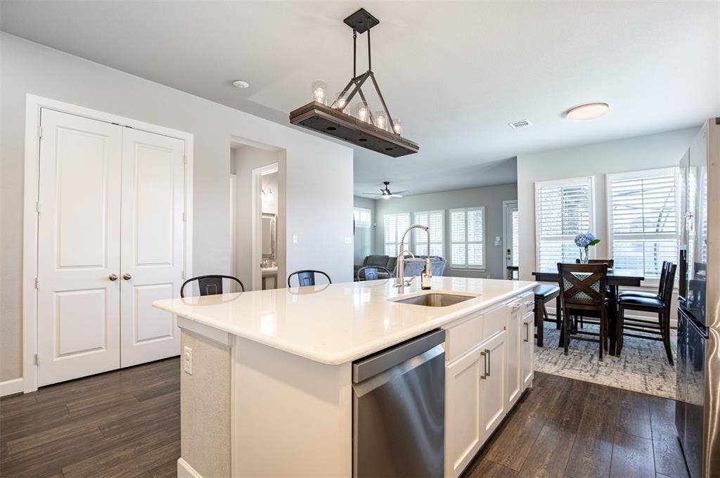 721 Matchbox Street, Argyle, TX 76226 Large kitchen island with decorative lighting and extra seating. Double doors lead to pantry.