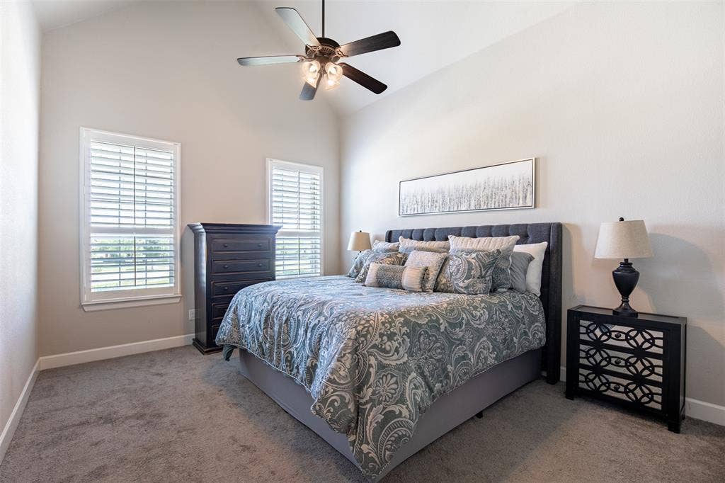 721 Matchbox Street, Argyle, TX 76226 Spacious primary bedroom featuring large, sun-drenched windows with custom, high-end plantation shutters for added privacy and timeless elegance.