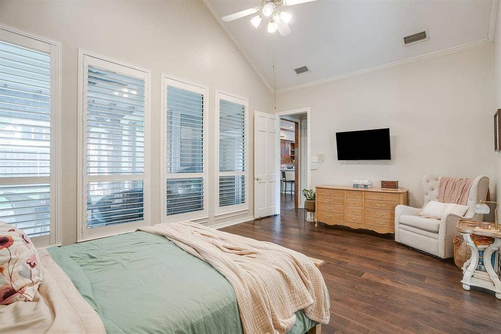 4624 Reunion Drive, Plano, TX 75024 Vaulted ceiling with a ceiling fan, wood-finish flooring, and multiple tall windows with plantation shutters
