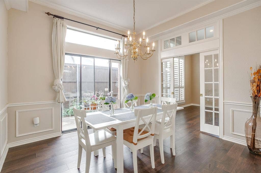 4624 Reunion Drive, Plano, TX 75024 Dining room featuring wood flooring, wainscoting, crown molding, slider, and a brass chandelier