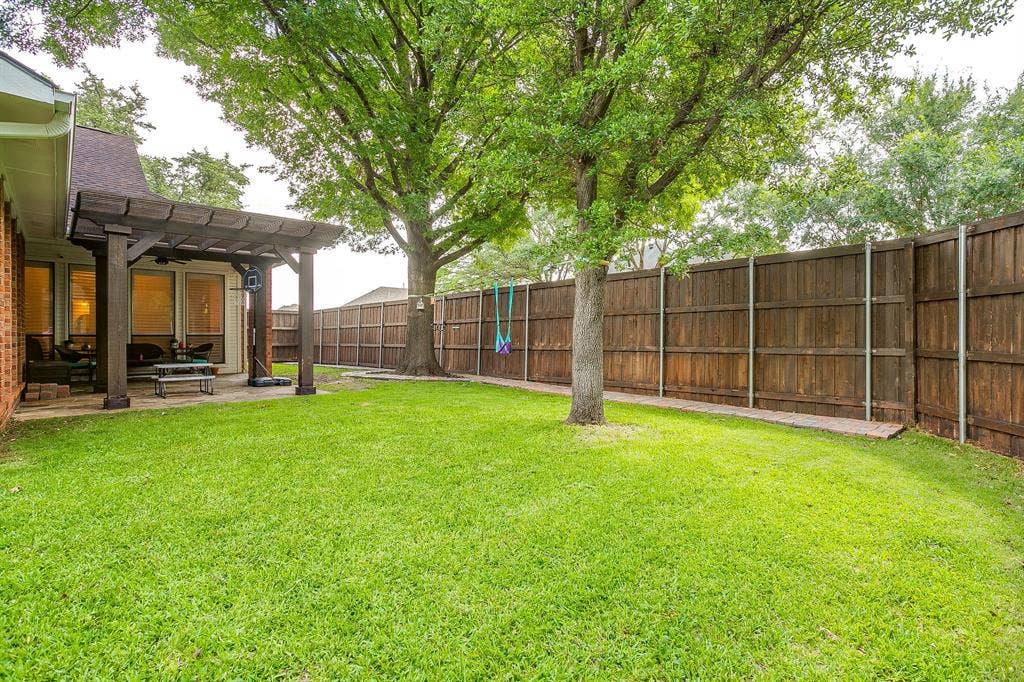 4624 Reunion Drive, Plano, TX 75024 Backyard area featuring a wooden pergola-covered patio and a wooden privacy fence