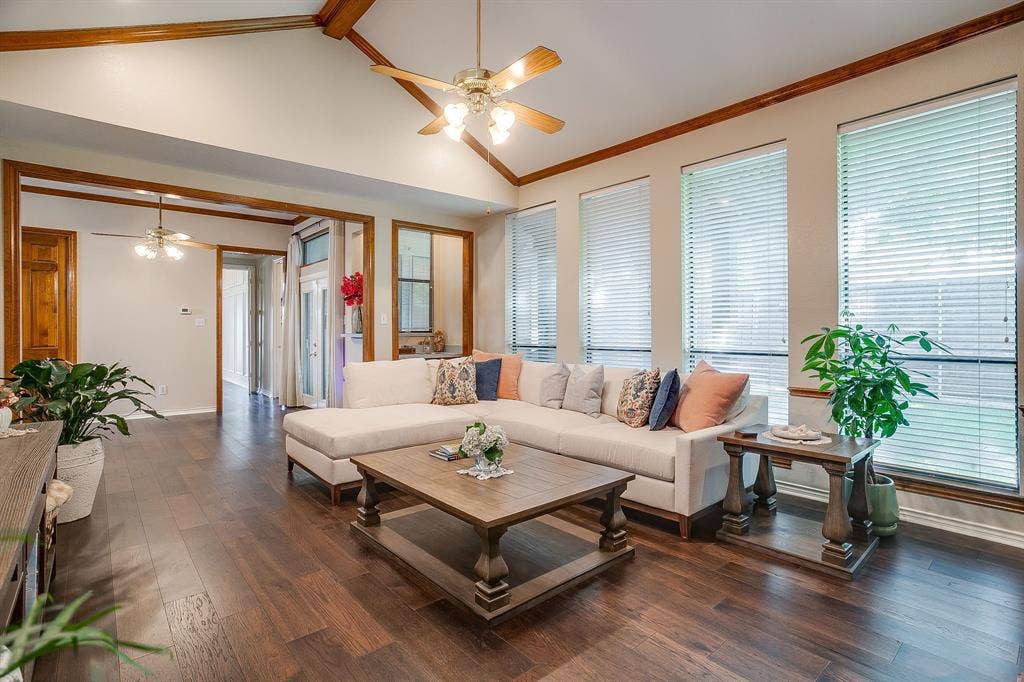 4624 Reunion Drive, Plano, TX 75024 Living space featuring wood-finish flooring, vaulted ceilings with exposed wood beams, and multiple windows