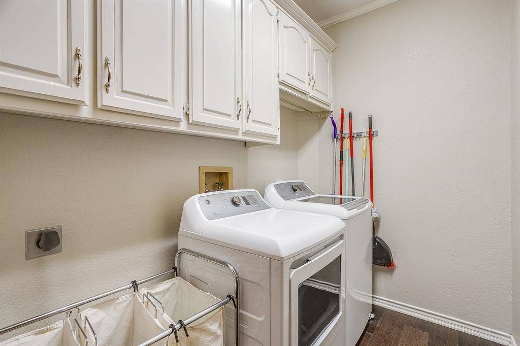 4624 Reunion Drive, Plano, TX 75024 Dedicated utility space featuring white upper cabinetry and wood flooring