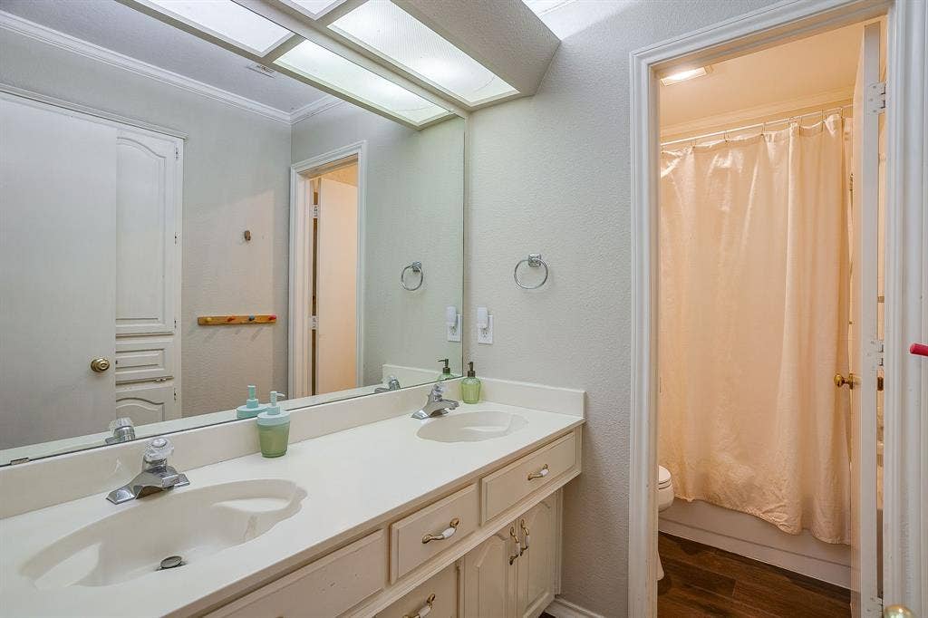 4624 Reunion Drive, Plano, TX 75024 Dual sink vanity with white countertops and white cabinetry. Combo tub/shower attached