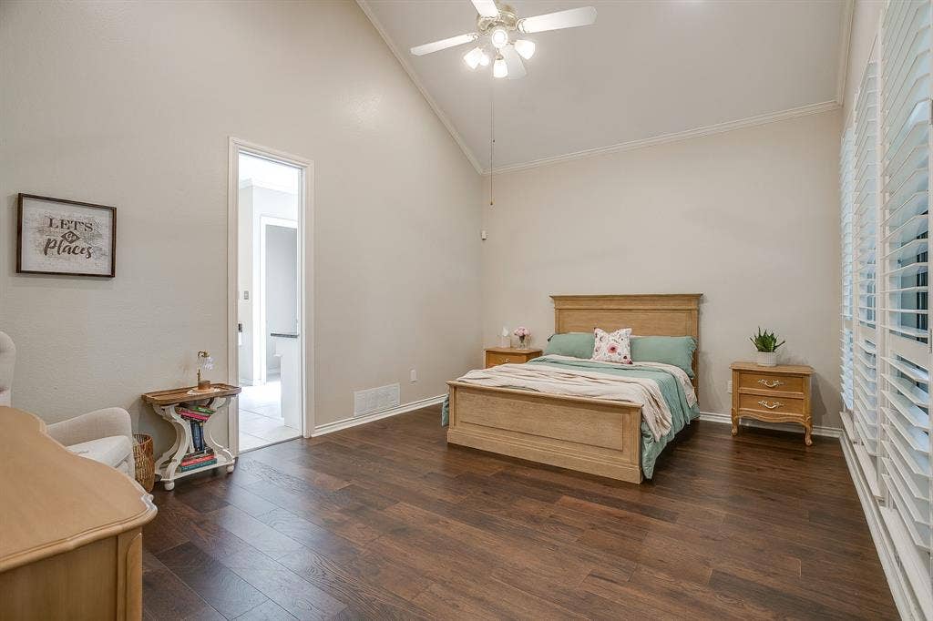 4624 Reunion Drive, Plano, TX 75024 Vaulted ceiling bedroom featuring wood flooring, a ceiling fan with integrated lighting, and plantation shutters