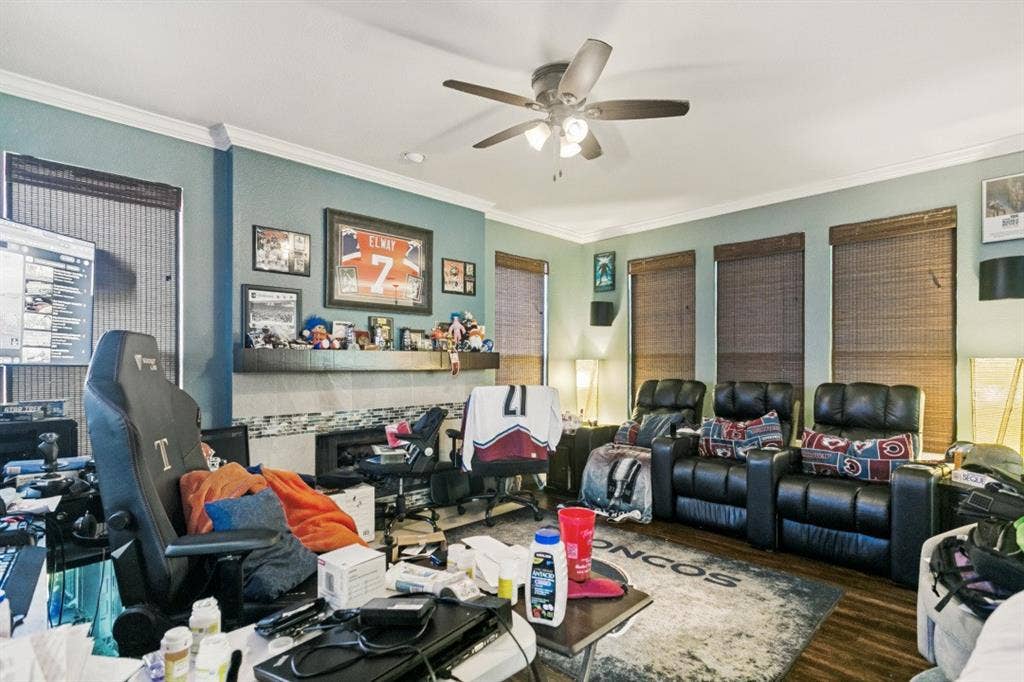 6713 Ashglen Place, Plano, TX 75023 Living space featuring a built-in fireplace with a tile surround and mantel, wood-finish flooring, and crown molding