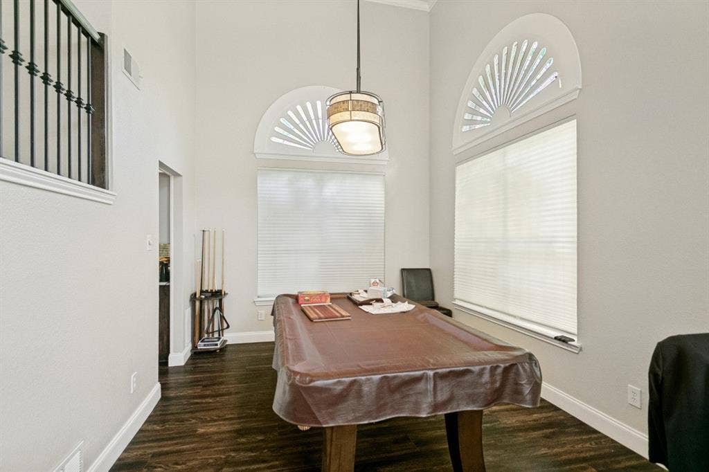 6713 Ashglen Place, Plano, TX 75023 Room featuring high ceilings, two arched transom windows, wood-finish flooring, and white baseboards