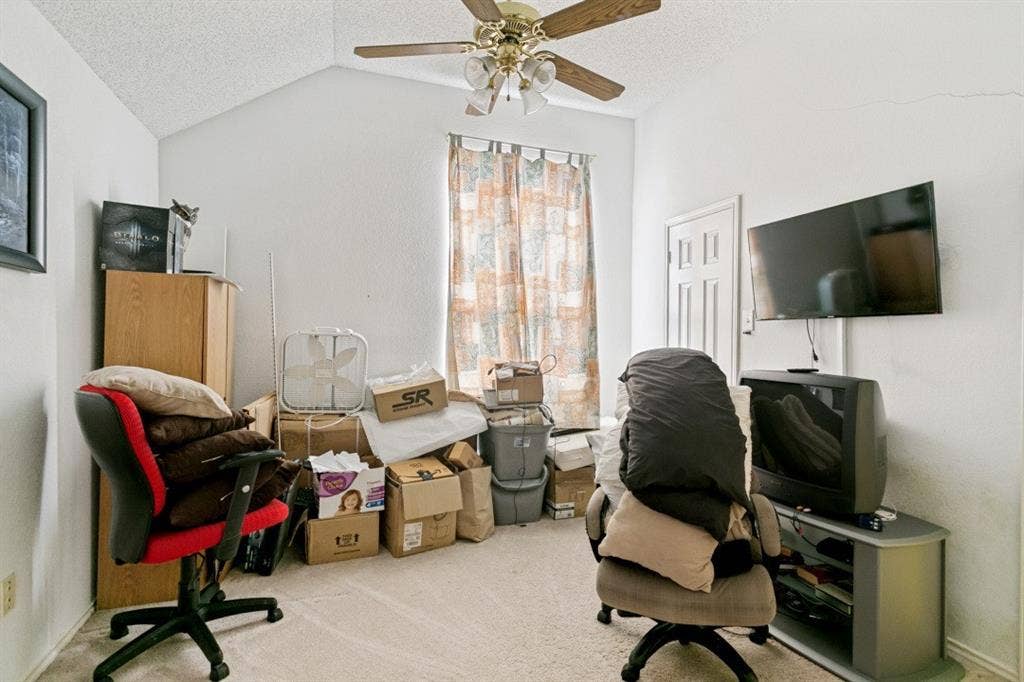 6713 Ashglen Place, Plano, TX 75023 Room featuring a vaulted ceiling with a ceiling fan, wall-to-wall carpeting, and a window with patterned curtains