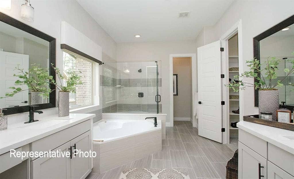 1324 Gardendale Hollow Lane, Anna, TX 75409 Spacious bathroom featuring dual vanities with quartz countertops, a separate soaking tub, and a glass-enclosed shower