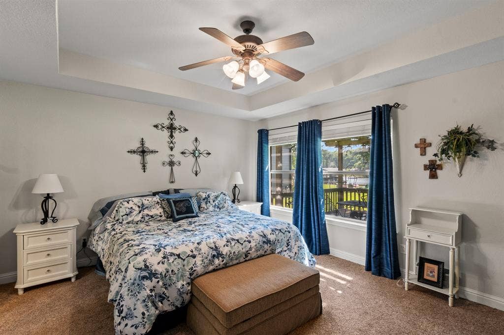 194 Bushwhacker Drive, Mabank, TX 75156 Waterside primary suite featuring peaceful lake views and direct patio access.