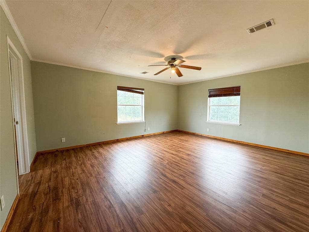 2749 Mcgregor South Loop, McGregor, TX 76657 Spacious room featuring wood-finish flooring, light green walls, and white trim