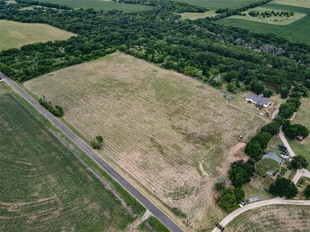 2749 Mcgregor South Loop, McGregor, TX 76657 Expansive land parcel featuring cultivated fields bordering a paved roadway