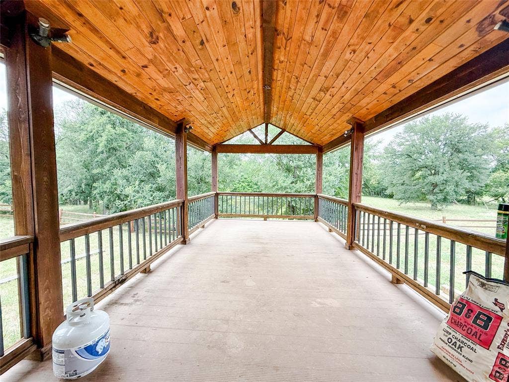 2749 Mcgregor South Loop, McGregor, TX 76657 Expansive covered porch featuring a natural wood ceiling, exposed beams, and a concrete floor