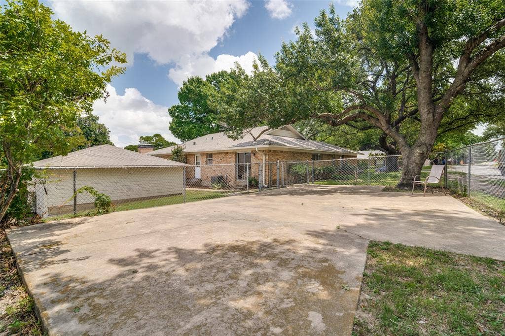 Fenced paved area at the corner of the property