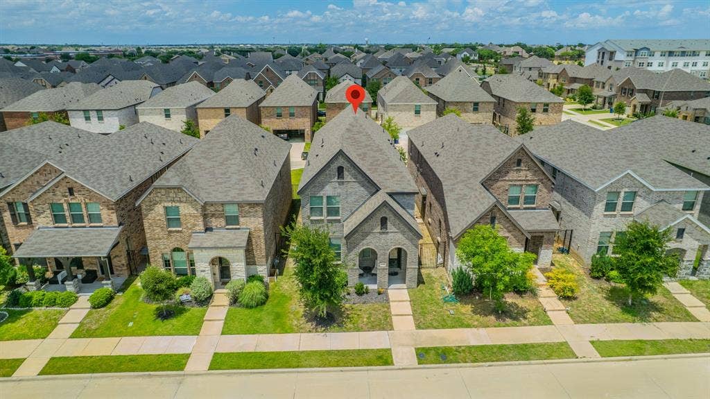 4129 Bullwhip Creek Lane, Sachse, TX 75048 Two-story residence featuring a gray brick and stone exterior with a prominent front-facing gable
