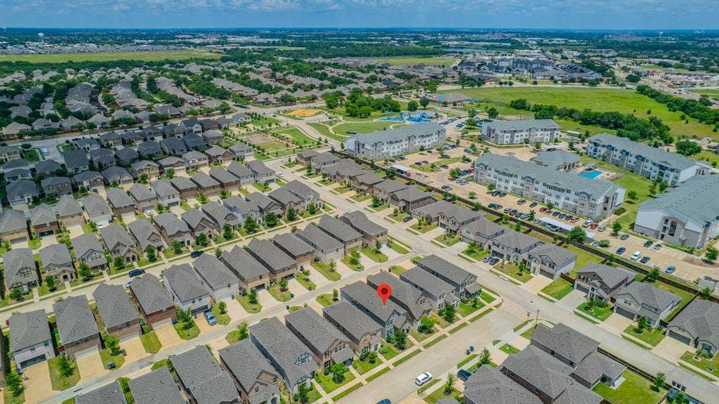 4129 Bullwhip Creek Lane, Sachse, TX 75048 Aerial perspective showcasing a residential neighborhood with uniform rooflines and manicured lawns