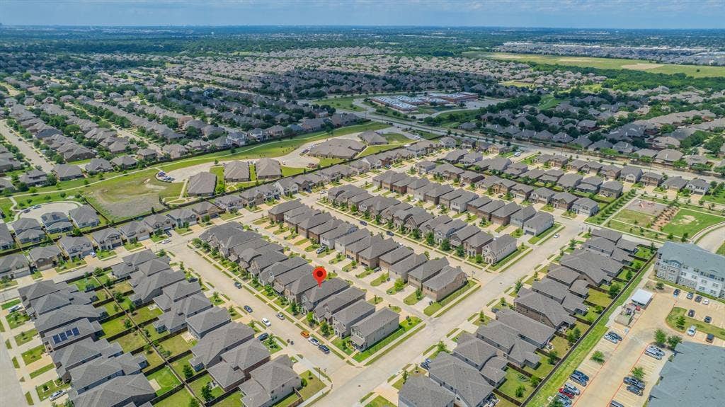 4129 Bullwhip Creek Lane, Sachse, TX 75048 Aerial perspective showcasing a residential neighborhood with uniformly designed homes and verdant green spaces