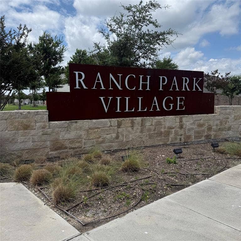 4129 Bullwhip Creek Lane, Sachse, TX 75048 Stone-clad entrance signage featuring a metal plaque with raised lettering