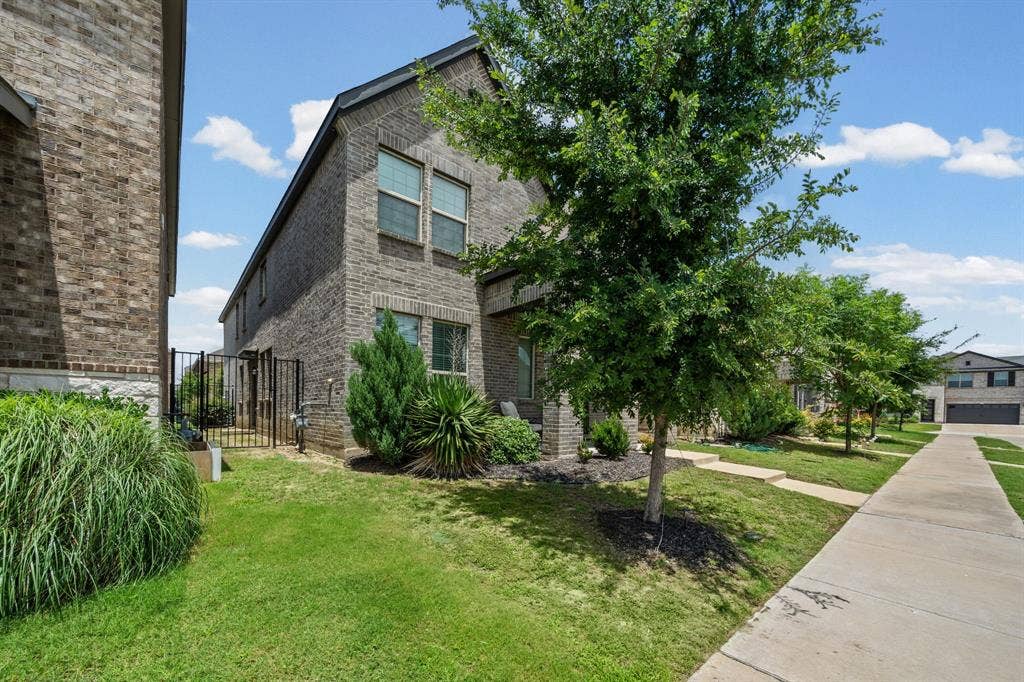 4129 Bullwhip Creek Lane, Sachse, TX 75048 Two-story brick exterior with a black roof