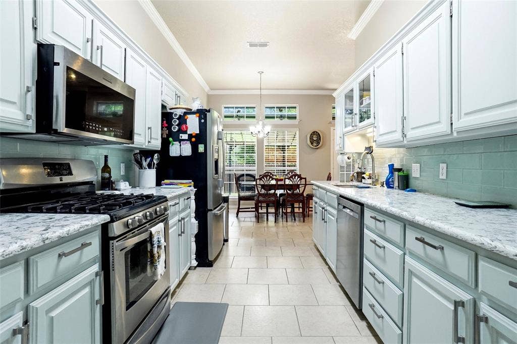 upper cabinets in white and lower cabinets in accent shade, gas range & stainless appliances